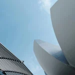 Dynamic view of sleek architectural designs reaching into a clear blue sky.