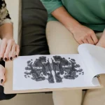 A close-up of a Rorschach inkblot test during a psychotherapy session, highlighting mental health care.